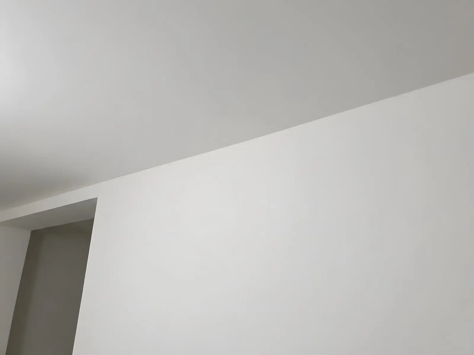 Le même angle enduit et poncé : mur et plafond lisses, plus aucun joint ne se devine