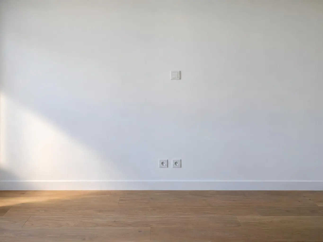 Le même mur lisse et blanc, interrupteur et prises posés à leur place, sans aucune trace de saignée